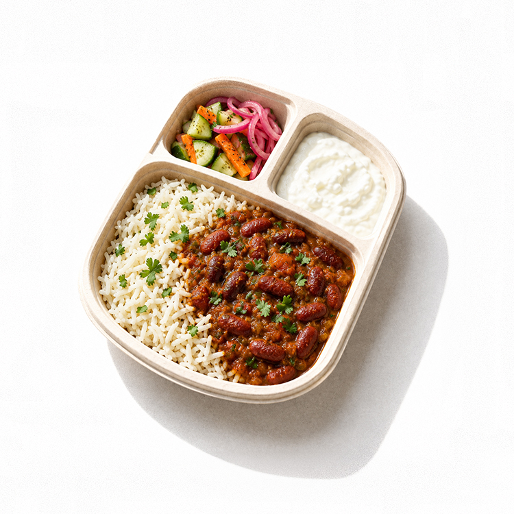 Rajma chawal bowl with steamed rice, salad, pickled onions and curd