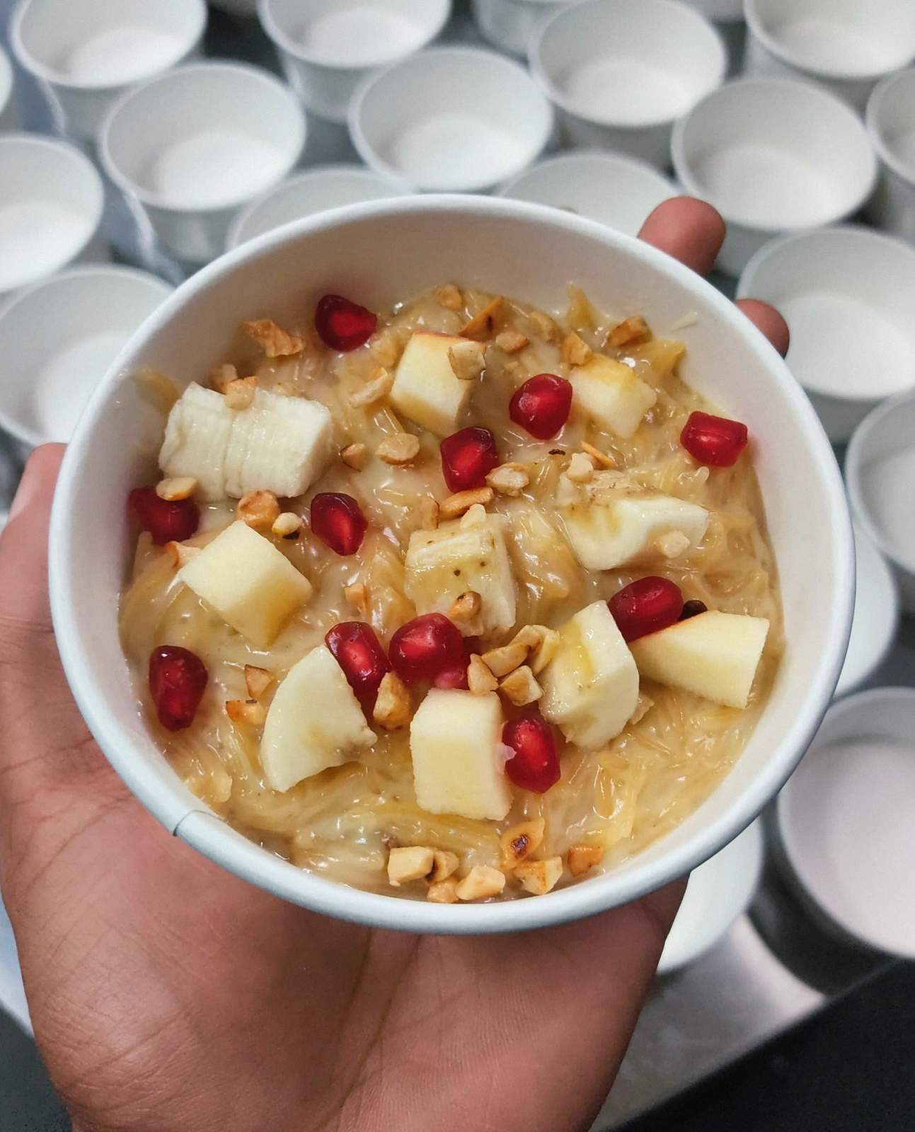 Creamy vermicelli dessert topped with fresh banana, apple, pomegranate seeds and chopped nuts, prepared at the Carb Theory kitchen in Bangalore.